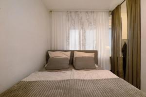 a bed with two pillows in a bedroom with a window at Gemütliche Wohnung in Reimsbach in Beckingen
