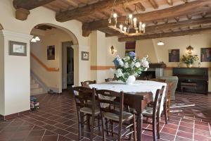 a dining room with a table and chairs and a piano at All Inclusive Villa Con Piscina in Camaiore