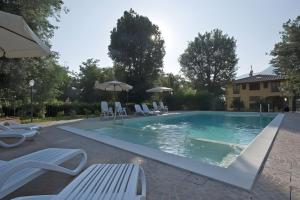 a swimming pool with chairs and umbrellas at All Inclusive Villa Con Piscina in Camaiore