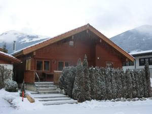 a house in the snow with a fence at Chalet Finkennest in Neukirchen am Großvenediger