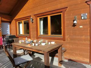 a wooden table on the back of a house at Chalet Finkennest in Neukirchen am Großvenediger