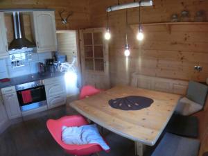 a small kitchen with a wooden table and red chairs at Chalet Finkennest in Neukirchen am Großvenediger +29 photos