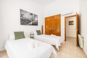 two beds in a room with white walls at Villa Ramón in Palma de Mallorca +23 photos