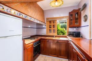 a kitchen with wooden cabinets and a stove top oven at Sa Fonteta Cala Morlanda in S'Illot