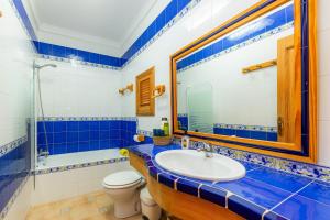 a blue and white bathroom with a sink and a toilet at Sa Fonteta Cala Morlanda in S'Illot +19 photos