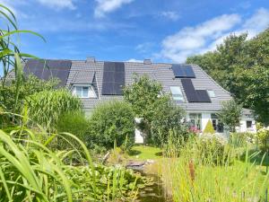 a house with solar panels on the roof at Ferienwohnung Alte Schule in Wester-Bargum