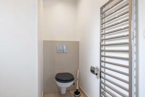 a bathroom with a toilet with a black seat at Ferienwohnung Alte Schule in Wester-Bargum +17 photos