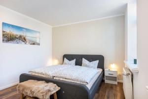 a bedroom with a king sized bed in a white room at Ferienwohnung Alte Schule in Wester-Bargum