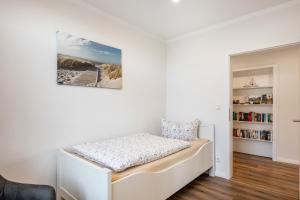 a bed in a room with a book shelf at Ferienwohnung Alte Schule in Wester-Bargum