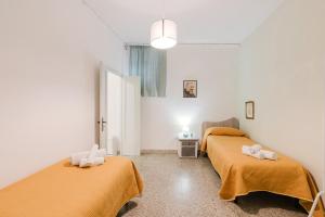 a room with two beds with towels on them at Beneath The Castle - Apartment in Corleone