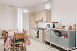 a kitchen with a table and a stove and a table and chairs at Beneath The Castle - Apartment in Corleone