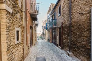 an alley in an old town with stone buildings at Beneath The Castle - Apartment in Corleone