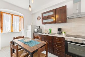 a kitchen with a wooden table and a dining room at Casa Rocca in Bosa