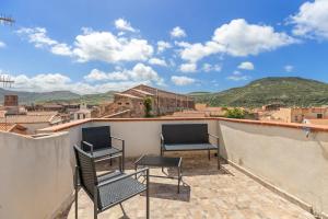 two chairs on a balcony with a view of a city at Casa Rocca in Bosa