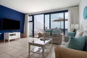 a living room with a couch and a tv at Ajaches 23 in Puerto Calero