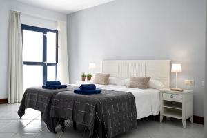 a bedroom with a large bed with blue towels on it at Ajaches 23 in Puerto Calero +22 photos