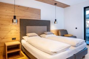 two beds in a room with wooden walls at Falsers Mountain Lodge in Cornedo all'Isarco
