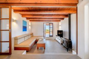 a living room with a couch and a tv at Casa S'Olibassa in La Mola