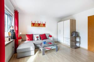 a living room with a gray couch and red pillows at Ferienwohnung Schwarzwaldhirsch in Unterkirnach