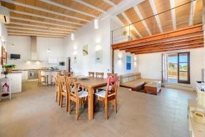 a kitchen and dining room with a wooden table and chairs at Casa S'Olibassa in La Mola