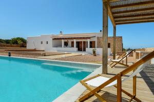 a villa with a swimming pool and a house at Casa S'Olibassa in La Mola