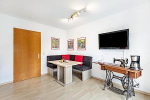 a room with a table and a couch and a television at Ferienwohnung Schwarzwaldhirsch in Unterkirnach