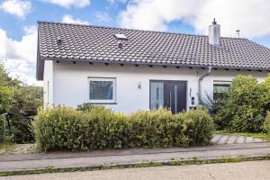 a white house with a black door at Ferienwohnung Schwarzwaldhirsch in Unterkirnach