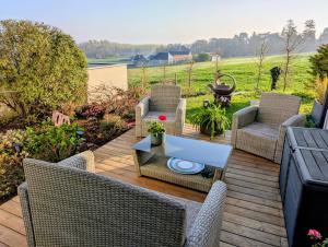 a patio with wicker chairs and a table at Un Thé sur la Loire in Ballan-Miré