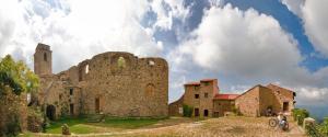an old stone building on a hill with clouds in the sky at Lovers' Nest - Unità 1 in Baiardo