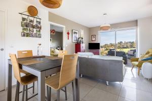 a dining room and living room with a table and chairs at Un Thé sur la Loire in Ballan-Miré