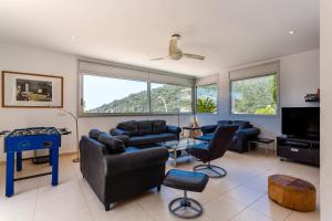 a living room with couches and a table and chairs at Exclusive Villa with pool seaview in Tossa de Mar
