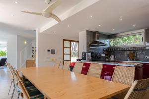 an open kitchen with a wooden table and chairs at Exclusive Villa with pool seaview in Tossa de Mar