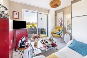 a living room with a white couch and a red cabinet at Un Thé sur la Loire in Ballan-Miré