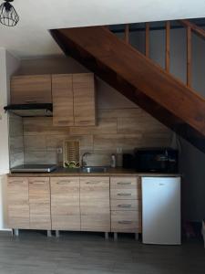 a kitchen with wooden cabinets and a white refrigerator at Nocowanie w młynie in Niedzica