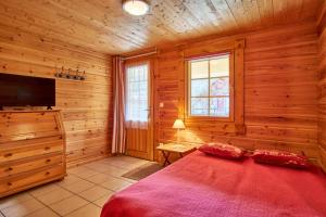 a bedroom with a bed in a wooden cabin at Chalet le Serac in Gresse-en-Vercors