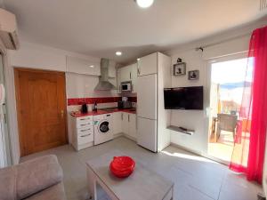 a kitchen with white appliances and a red bowl on a table at Estudio lola in Nerja