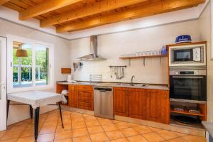 a kitchen with a sink and a stove top oven at Villa Can Neo in Santanyi