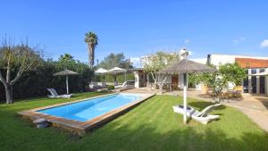 a swimming pool with two chairs and an umbrella at Collet De Manacor in Manacor