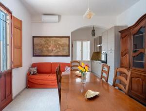 a living room with a table and a red couch at Villa del Mirto Punta Prosciutto in Torre Lapillo