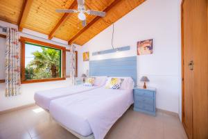 a bedroom with a bed and a ceiling fan at Villa Can Neo in Santanyi +29 photos