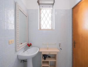 a white bathroom with a sink and a mirror at Villa del Mirto Punta Prosciutto in Torre Lapillo +17 photos