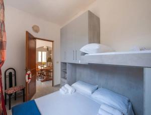 a bedroom with a bunk bed with white sheets and pillows at Villa del Mirto Punta Prosciutto in Torre Lapillo