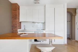 a kitchen with white cabinets and a wooden table at Casa Mar y Luz in Morro del Jable +10 photos