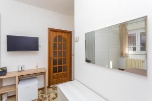 a room with a mirror and a tv on the wall at Sentiti A Casa - Bronte in Bronte
