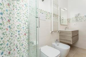 a bathroom with a toilet and a glass shower at Sentiti A Casa - Bronte in Bronte