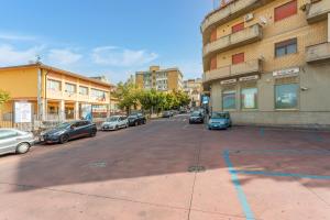 an empty parking lot with cars parked next to a building at Sentiti A Casa - Bronte in Bronte