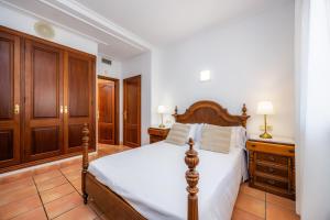 a bedroom with a large bed and wooden cabinets at Dofí in Cala Millor