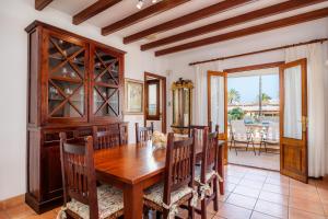 a dining room with a wooden table and chairs at Dofí in Cala Millor