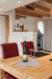 a bottle of wine sitting on top of a wooden table at Ferienwohnung Habichthorst in Naumburg