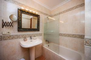a bathroom with a sink and a shower and a mirror at Dofí in Cala Millor +25 photos